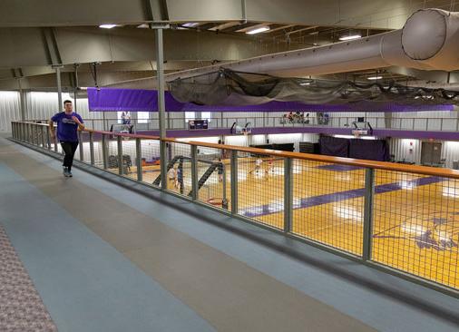 male jogging on walking track above intramural gym court